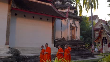 Junge-Thailändische-Buddhistische-Mönche,-Die-Bei-Sonnenuntergang-Auf-Dem-Tempelgelände-Spazieren