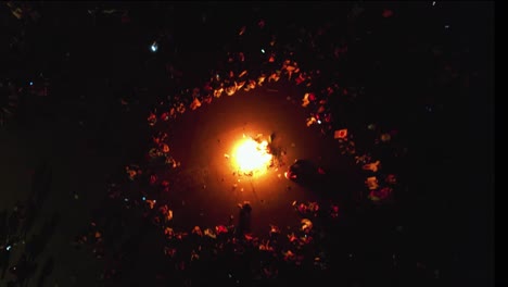 Aerial-view-above-a-bonfire-in-middle-of-refugees-camping-on-the-streets-of-a-city---top-down,-drone-shot