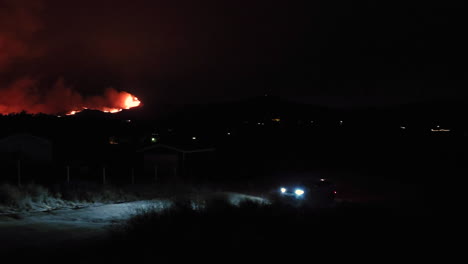 A-car-driving-from-a-wildfire-site-at-night