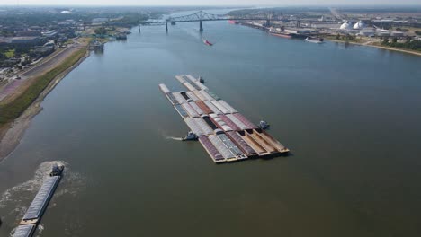 Tugboat-Pushing-Barges-on-Mississippi-River-in-Baton-Rouge,-Louisiana-Aerial-Tracking-Left