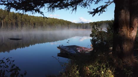 Lake-mist-on-shore-with-dock-garbage-floating-Enid-British-Columbia-Canada