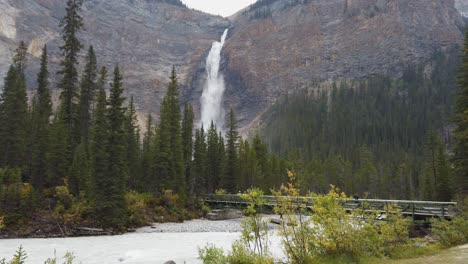 Großer-Wasserfall-Takakkaw-Falls-Yoho-Nationalpark-Britisch-Columbia-Brücke-über-Den-Fluss-Mit-Touristenkrabben
