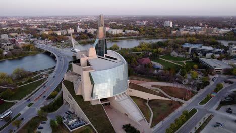 Aerial-view-passing-the-Canadian-Museum-for-Human-Rights-overlooking-traffic-on-the-Esplanade-Riel-Footbridge,-in-Winnipeg,-Canada