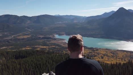 Hiker-taking-photos-on-peak-at-Barrier-Lake-Kananaskis-Alberta-circling