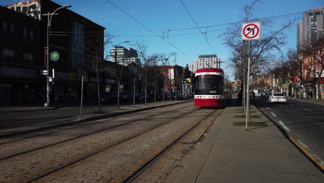 Wide-shot-of-northbound-streetcar-passing-by-on-Spadina-Avenue-in-Toronto
