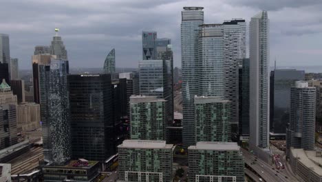 Aerial-view-approaching-high-rise,-in-South-Core,-Toronto,-cloudy-fall-day-in-Ontario,-Canada