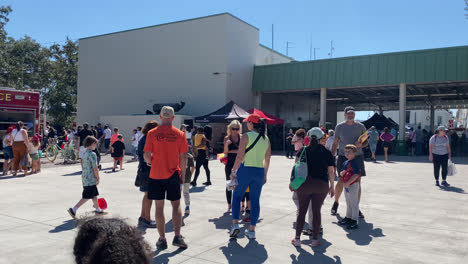 Huge-Crowd-of-People-at-an-Open-House-Fire-and-Safety-Demonstration-Event-at-the-Fire-House-with-Fire-Truck-and-Ambulance-on-display-for-the-public-to-see,-Tampa-Florida,-Panning-Shot