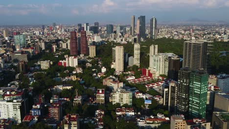 Aerial-view-overlooking-the-cityscape-of-Polanco,-golden-hour-in-Mexico-city---tilt,-drone-shot