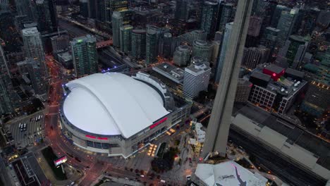 Aerial-view-overlooking-the-Rogers-centre,-dusk-in-downtown-Toronto,-Canada---high-angle,-orbit,-drone-shot