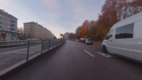 Driving-POV:-Autumn-leaves-on-trees-during-morning-commute-into-city