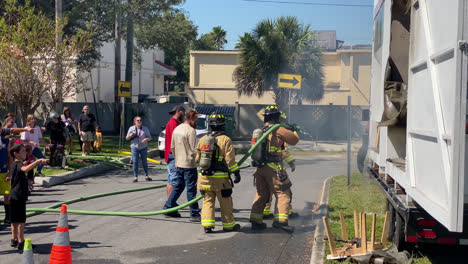 Fire-Fighters-Spraying-Down-Burning-Couch-and-Rug-For-an-Educational-Demonstration-on-Fire-and-Safety-at-the-Anual-Fire-Station-Open-House-in-Tampa-Florida