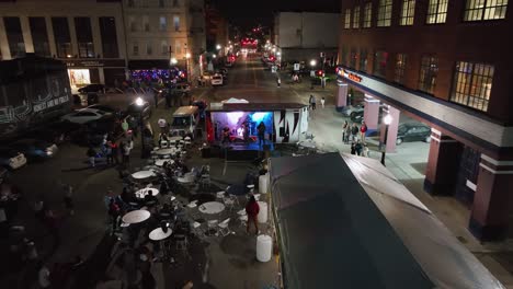 Aerial-view-towards-a-band-playing-on-the-streets-of-Illuminated-Cincinnati,-Blink-festival-in-Ohio,-USA