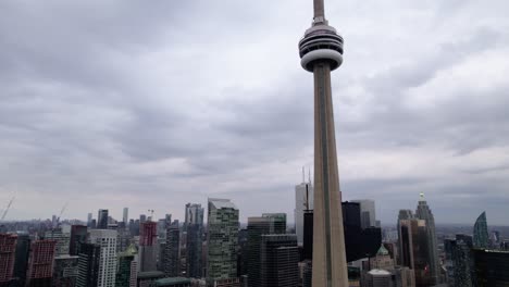 Aerial-view-of-the-cityscape-and-the-CN-tower-in-downtown-Toronto,-in-gloomy-Ontario,-Canada---tilt,-drone-shot