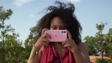 Curly-woman-taking-a-picture-with-her-Iphone