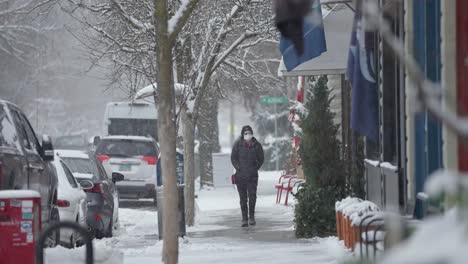 Aufnahme-Einer-Eingewickelten-Frau,-Die-Einen-Schneebedeckten-Bürgersteig-Im-Ländlichen-Amerika-Hinuntergeht