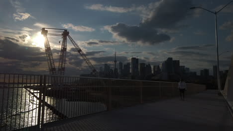 Late-afternoon-wide-shot-from-the-new-Cherry-Street-South-Bridge-with-pedestrian-crossing-and-large-crane-and-Toronto-skyline-in-the-distance