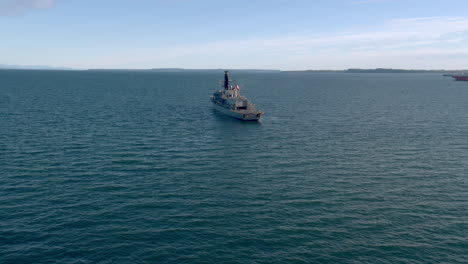 Aerial-View-Around-Stern-Of-Chilean-Navy-Frigate-Travelling-Through-Puerto-Montt-Bay