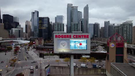Aerial-view-away-from-the-Rogers-centre-sign-in-cloudy-Toronto,,-Canada---pull-back,-drone-shot