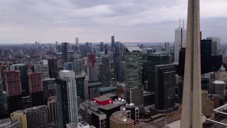 Aerial-view-of-office-buildings-and-the-CN-tower-in-Toronto-city,-Canada---descending,-drone-shot
