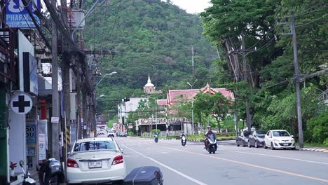 Street-view-in-Phuket-Town,-Thailand-with-motorcycles-driving-by
