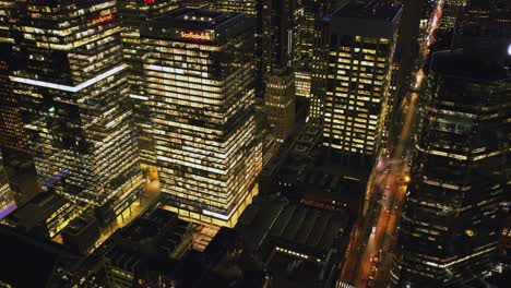 Aerial-tilt-Hyperlapse-of-traffic-and-night-lit-high-rise-in-Toronto-city,-Canada