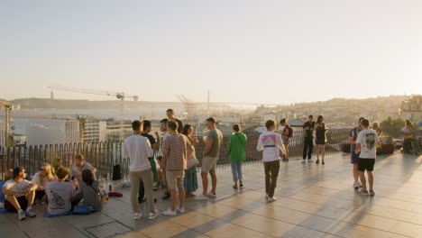 Sonnenuntergangslandschaft-über-Den-Dächern-In-Lissabon-Mit-Jungen-Menschen