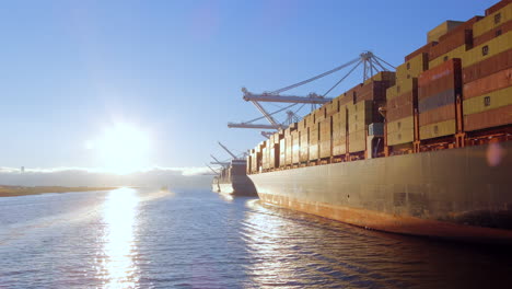 Sunlit-Waters-Of-Estuary-With-Cargo-Vessel-Loaded-With-Intermodal-Containers-Docked-In-The-Port-Of-Oakland-In-California,-USA