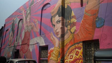 Cinematic-tilt-down-shot-revealing-artwork-graffiti-of-Indian-Bollywood-actresses-is-drawn-on-the-wall-in-Chapel-Road,-Bandra,-India