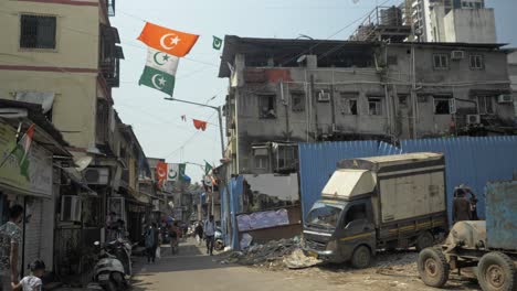 Static-shot-of-tricolor-Islamic-flags-hanging-through-houses,-in-the-middle-of-streets-of-Bandra,-Mumbai