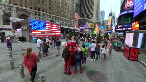 Acercándose-A-Times-Square-En-Nueva-York-Con-Una-Enorme-Bandera-Americana-Iluminada-En-Segundo-Plano.