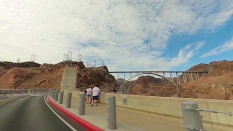 Driving-over-the-iconic-Hoover-Dam-as-seen-from-cabriolet-with-bridge-in-background