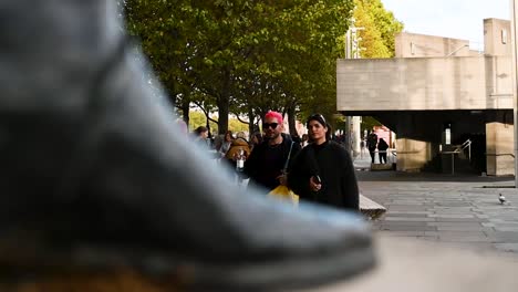 Paar-Zu-Fuß-Vorbei-An-Der-Statue-Von-Laurence-Olivier,-London,-Vereinigtes-Königreich
