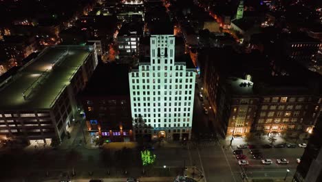 Aerial-view-away-from-a-Illuminated-building-in-downtown-Cincinnati,-BLINK-festival-in-Ohio,-USA---pull-back,-drone-shot