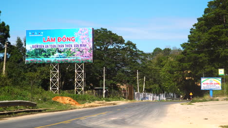 static-shot-of-welcome-to-Lam-Dong-province-signal-of-entrance-in-souther-vietnam-tourist-destination-with-a-truck-pass-by