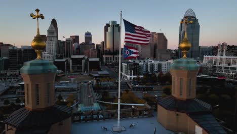 Aerial-view-around-US-flag-waving-in-front-of-skyscrapers---orbit,-drone-shot