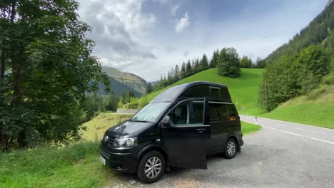 A-VW-campervan-parked-in-a-lay-by-at-the-side-a-road-in-the-Alps