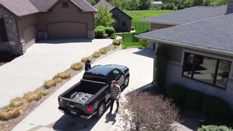 Drone-push-in-on-a-home-improvement-crew-getting-out-of-a-truck-with-tools