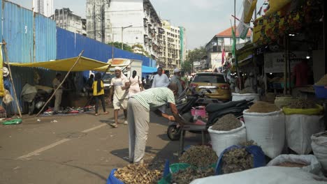 Statische-Aufnahme-Eines-Mannes,-Der-Seinen-Ladenbereich-Putzt,-Und-Menschen,-Die-Trockenfisch-Vom-ältesten-Und-Größten-Großhandelsmarkt-Für-Trockenfisch-In-Wadala,-Mumbai,-Kaufen