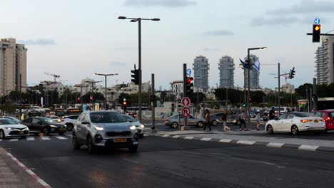 Pedestrians-crossing-a-busy-street-at-traffic-light,-Tel-Aviv,-Israel