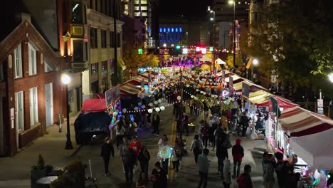 Aerial-view-of-people-walking-between-stalls-at-city-street-in-Cincinnati,-USA,-at-BLINK-the-festival-of-lights-and-art