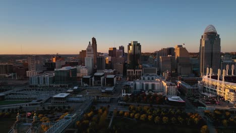 Aerial-view-of-the-Cincinnati-skyline,-during-a-colorful,-fall-evening---pull-back,-drone-shot