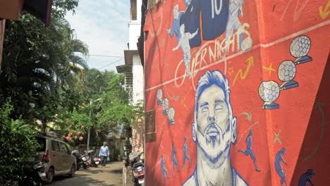 Revealing-shot-of-street-wall-mural-art-of-star-footballer-Lionel-Messi-on-the-streets-of-Chapel-Road,-Bandra,-India