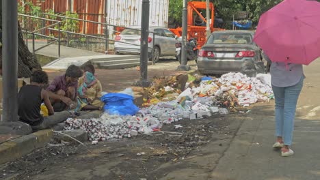 Static-shot-of-a-group-of-Asian-ragpickers-disposing-off-expired-medicines,-tablets,-syrups-in-the-middle-of-city's-dry-rubbish-spot
