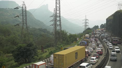Static-aerial-shot-of-traffic-congestion-on-multi-lane-Pune-Mumbai-Expressway-carved-through-mountains