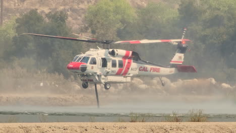 Firefighting-Firehawk-is-hovering-over-the-lake-to-refills-water-tank,-Fairview-fire,-Hemet