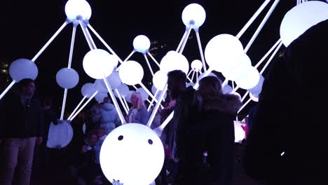 People-interact-with-glowing-illuminated-Affinity-neuron-touch-artwork,-Chavasse-park,-Liverpool-River-of-light