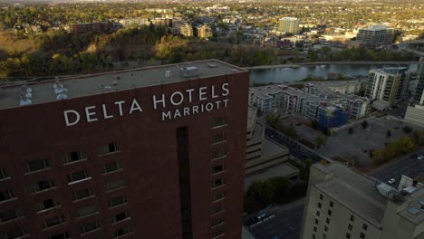 Aerial-view-in-front-to-the-Delta-hotels-Marriott-building-in-downtown-Calgary,-Canada---descending,-tilt,-drone-shot