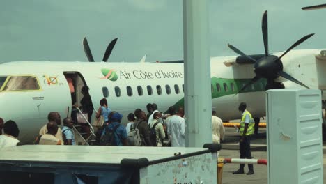 African-Passengers-Getting-Off-Airport-Bus-to-Board-an-Air-Cote-d'Ivoire-Bombardier-DHC-8-Q400-Airplane-at-Abidjan-Félix-Houphouët-Boigny-International-Airport