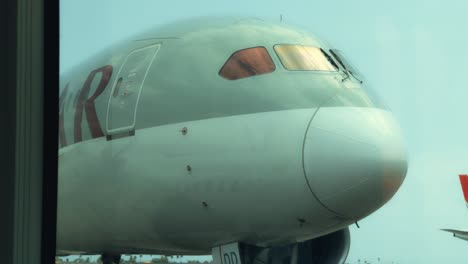 Qatar-Airways-Boeing-787-Dreamliner-at-Gate,-nose-view-from-Inside-inside-a-bus,-at-Abidjan-Félix-Houphouët-Boigny-International-Airport