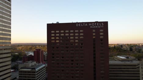 Aerial-view-in-front-to-the-Delta-hotels-Marriott-building-in-Calgary-city,-Canada---ascending,-tilt,-drone-shot